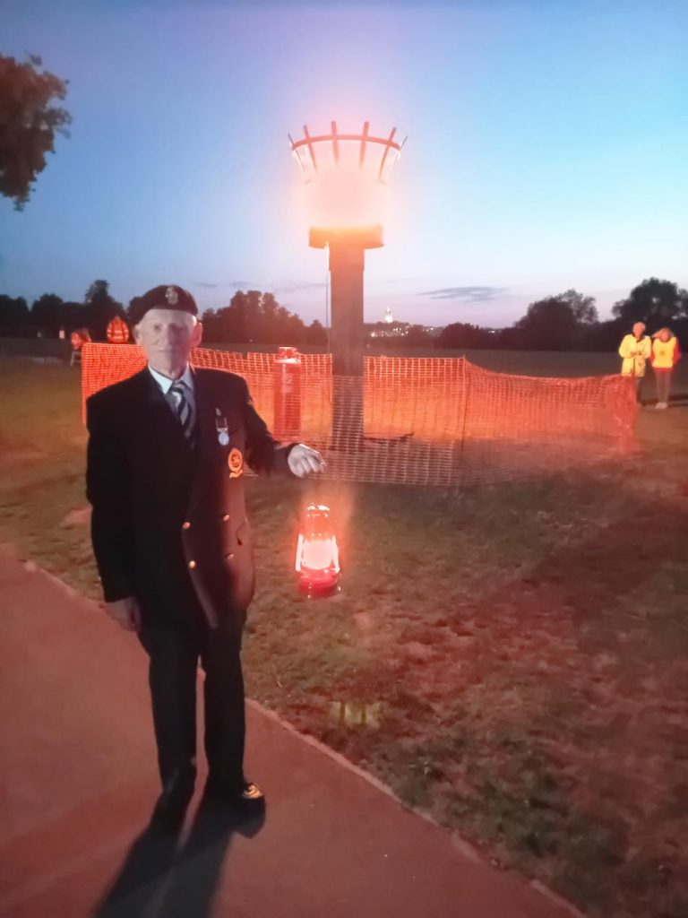 VE Day 80 Veteran holding lamplight of peace